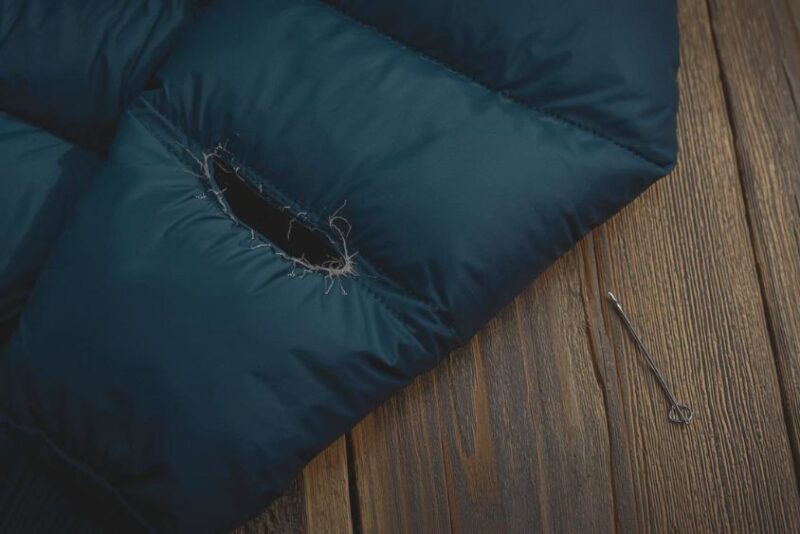 Close-up of a torn down jacket laid flat on a table